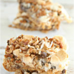 Homemade s'more bars stacked on top of each other with parchment paper