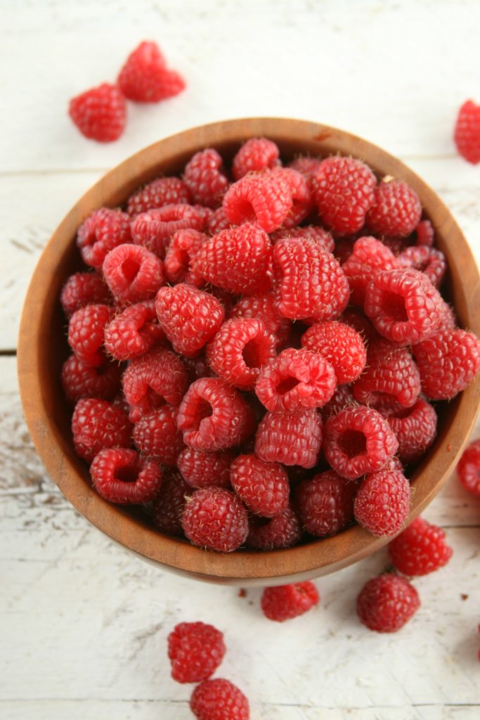 fresh raspberries in a small wooden bowl