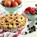 Peach medley pie with weaved crust in a vintage Polish pottery floral pie plate