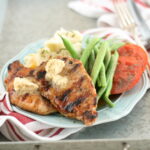 Maple glazed pork chops sitting on light blue plate in galvanized serving tray