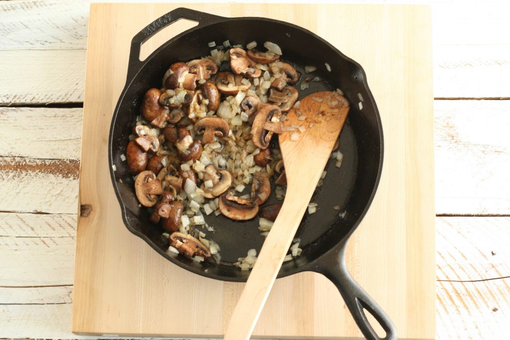 browned mushrooms and onions in a cast iron skillet