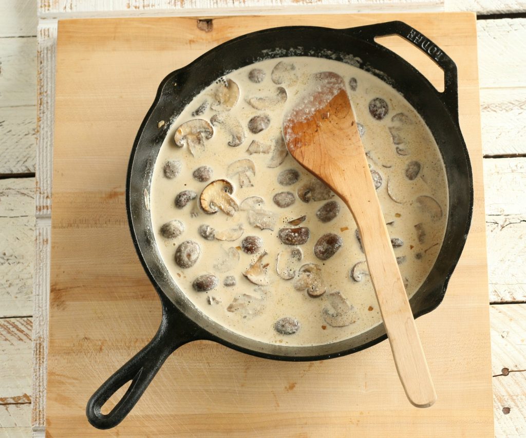 browned mushrooms in a cream sauce in a cast iron skillet