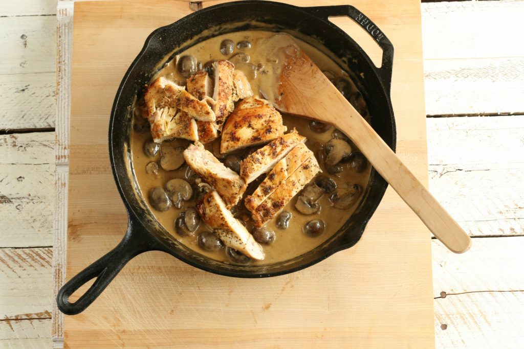 chicken and mushrooms in a cream sauce in a cast iron skillet