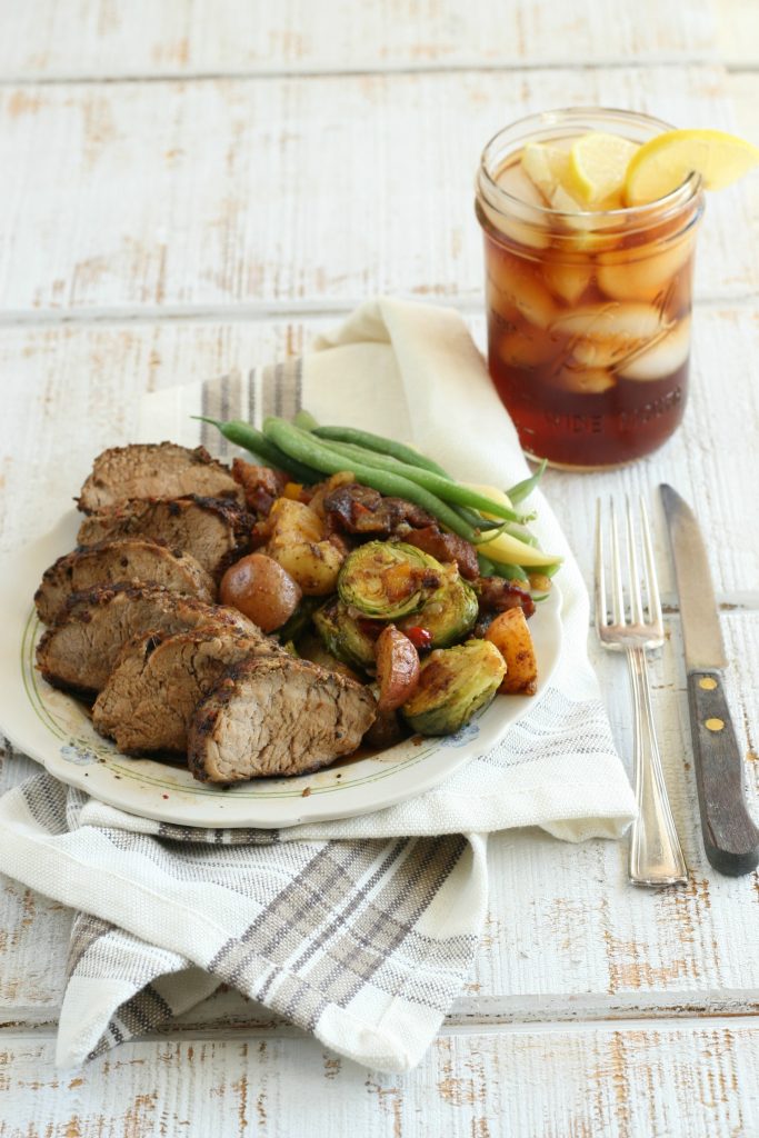 Sliced pork tenderloin with brussel sprouts, fresh green beans, and a glass of sweet tea