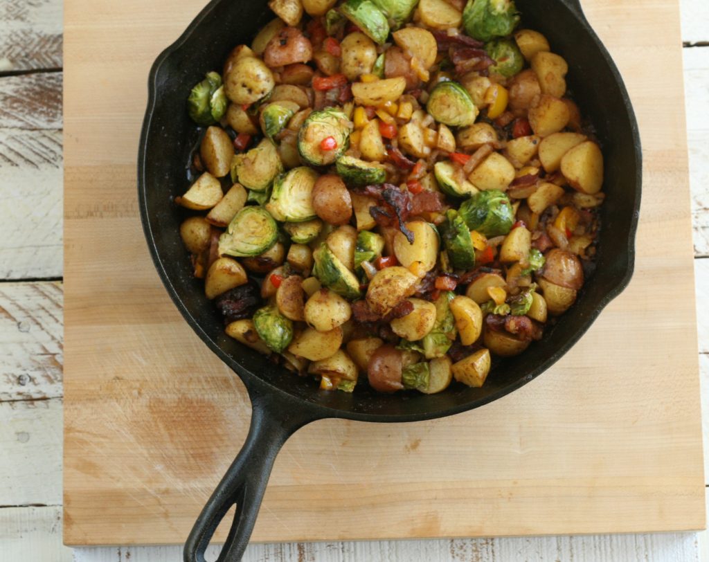 potatoes and brussel sprouts in a cast iron skillet