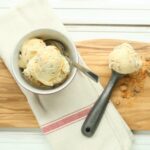 butterfinger ice cream and vintage ice cream scoop sitting on wooden cutting board