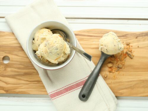 butterfinger ice cream and vintage ice cream scoop sitting on wooden cutting board