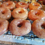 homemade glazed doughnuts on baking rack drying