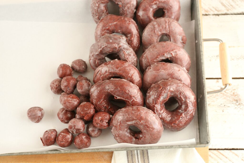 Red velvet cake doughnuts sitting in a galvanized tray