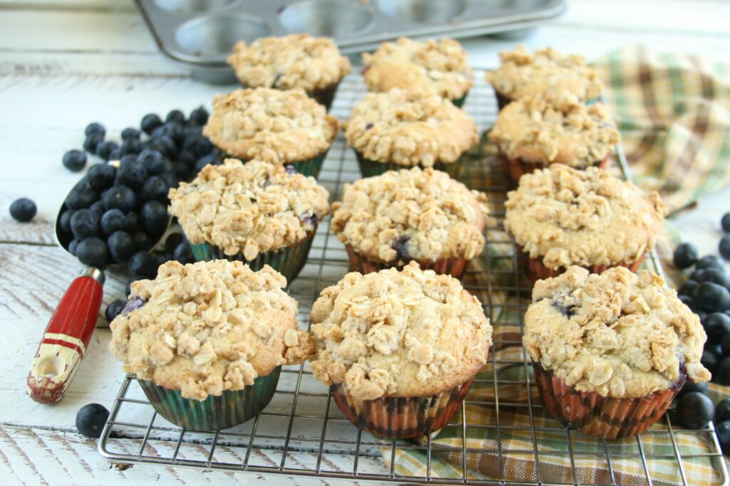 Freshly baked blueberry muffins cooling on a baking rack