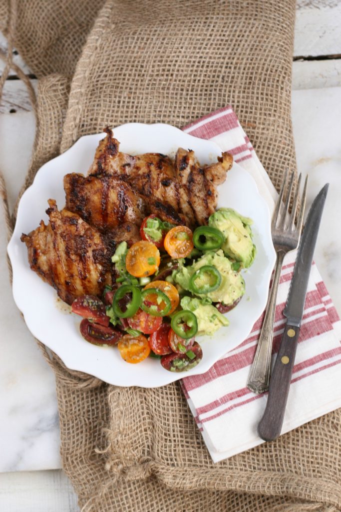 grilled chicken with avocado tomato salad and fork