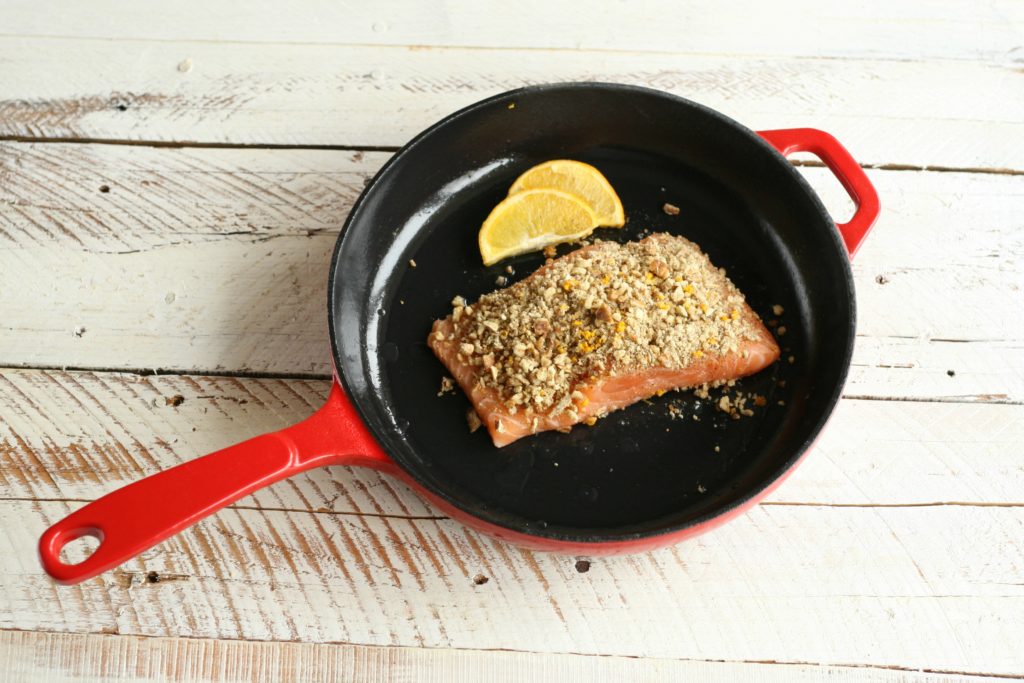 Maple Pecan Crusted Salmon in red enamel coated cast iron skillet cooking