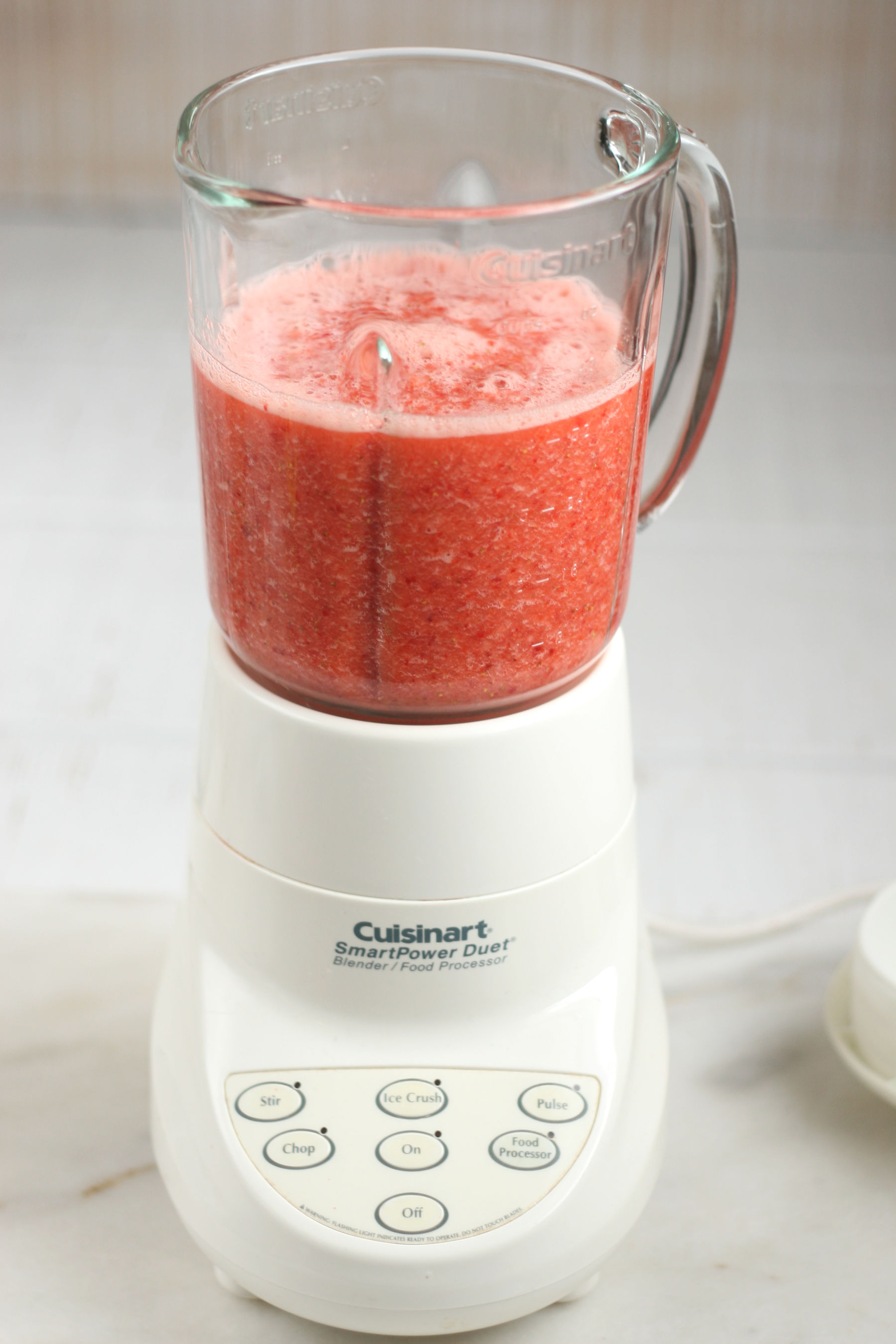 fresh strawberries blended together with water in a blender.