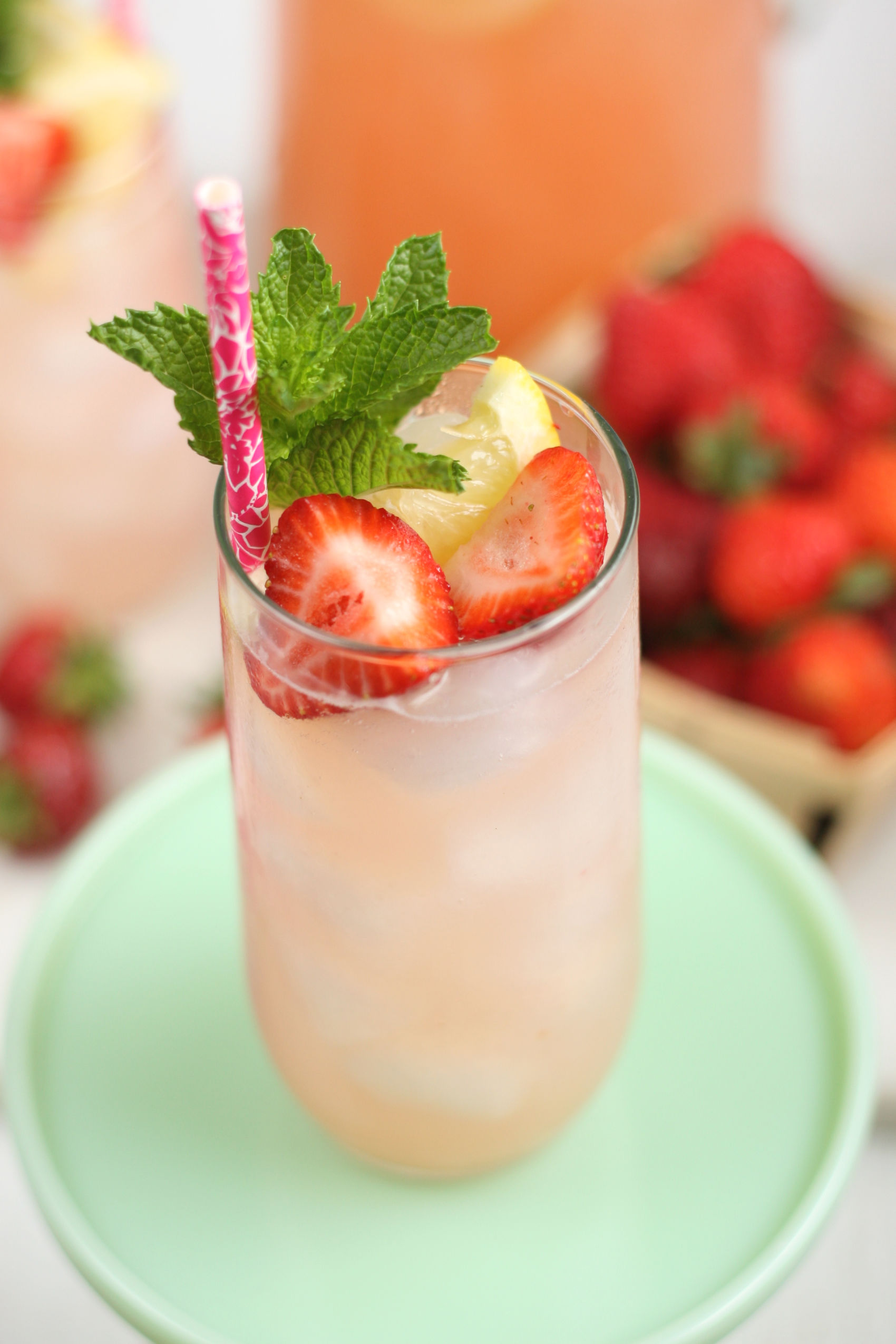 Strawberry lemonade in a glass with fresh strawberry slices, lemon slices, and fresh mint.