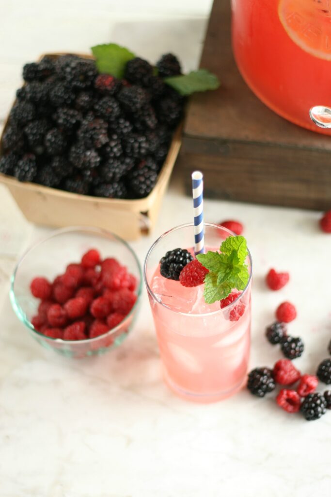 glass of blackberry lemonade with paper straw