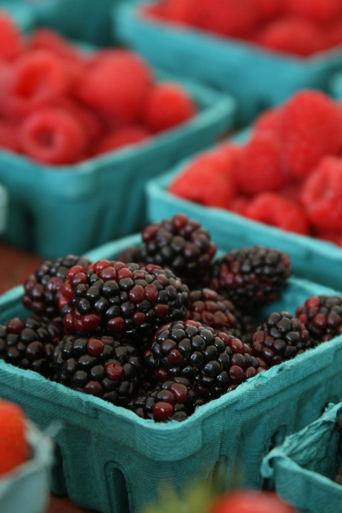 blackberries and raspberries in pint containers at the farm