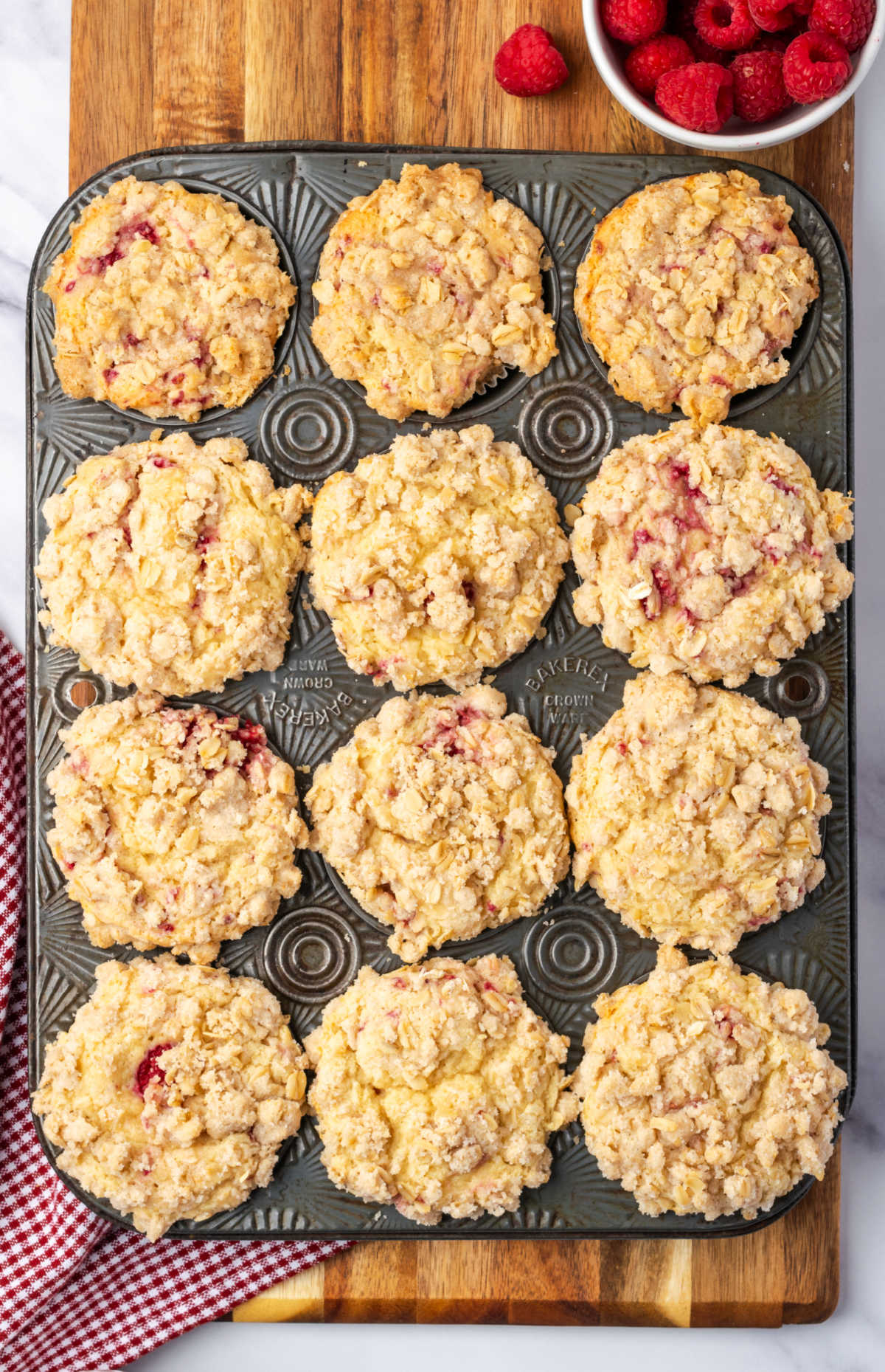 Baked raspberry muffins with oat crumb topping.