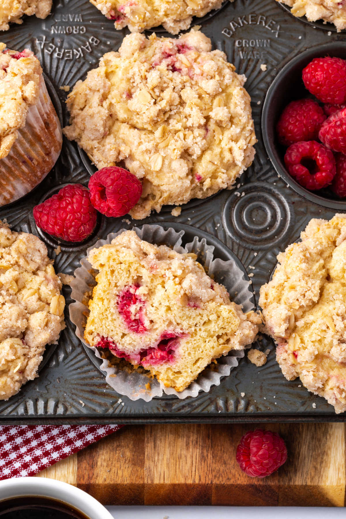 Muffins with crumb topping and raspberries in vintage muffin pan.