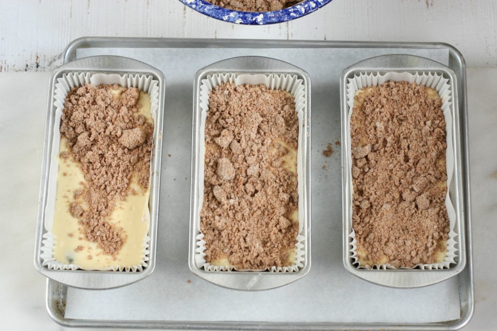 garniture de streusel à cuiller sur une pâte à gâteau au café dans des moules à pain