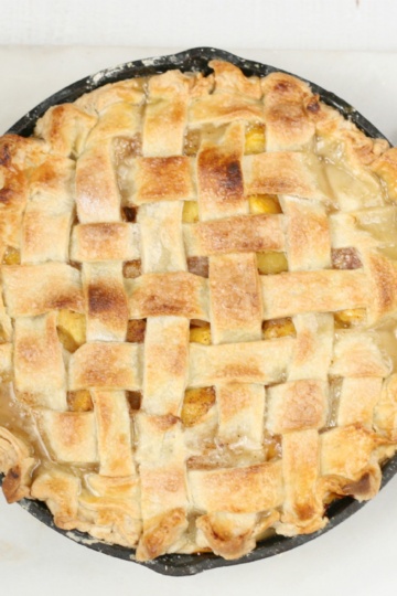homemade peach pie in 2-handle Lodge cast iron pan