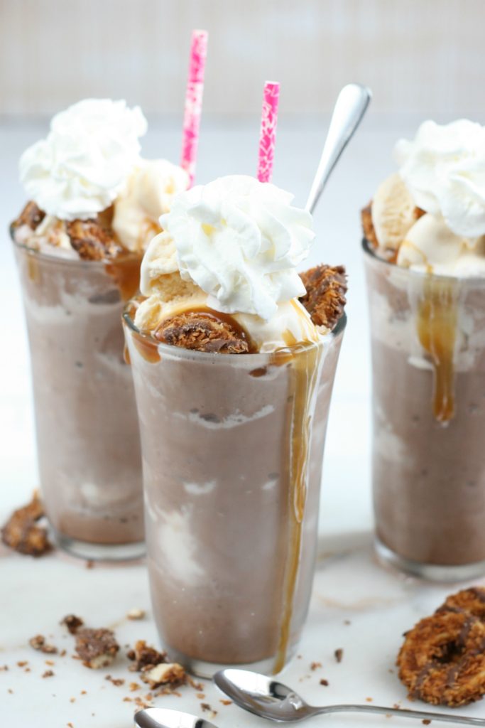 frozen hot chocolate in drinking glasses with whipped cream on top and cookie pieces