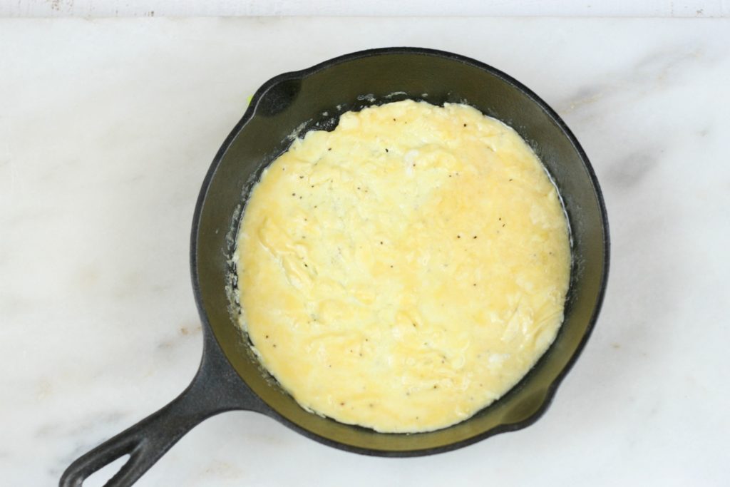 cooking an omelet in a small cast iron skillet
