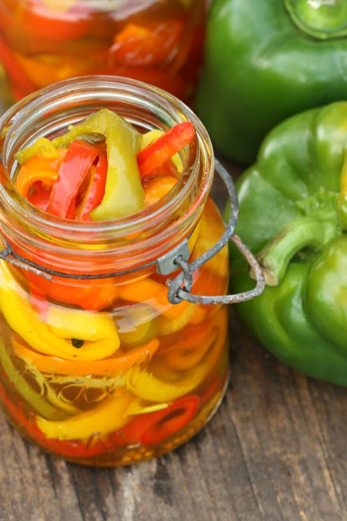 Sweet pickled Peppers in vintage Mason Jars on reclaimed wood boards.