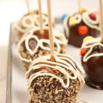 caramel chocolate apples rolled in toasted coconut on sheet pan