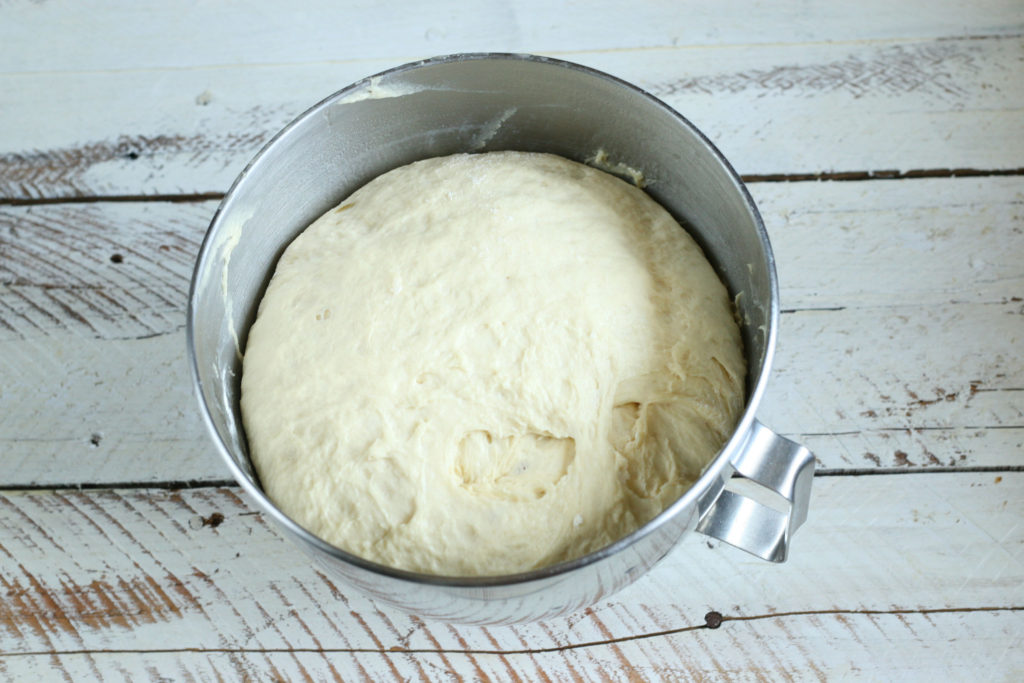 sourdough dough rising in metal mixing bowl.