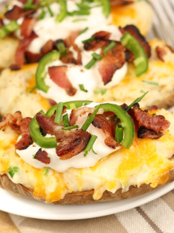twice baked potatoes with sour cream, bacon, chives, and jalapeno slices