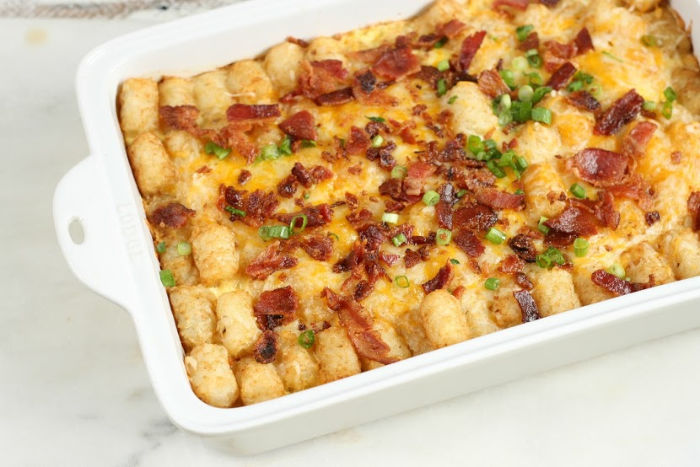 breakfast tater tot casserole in a white ceramic baking dish