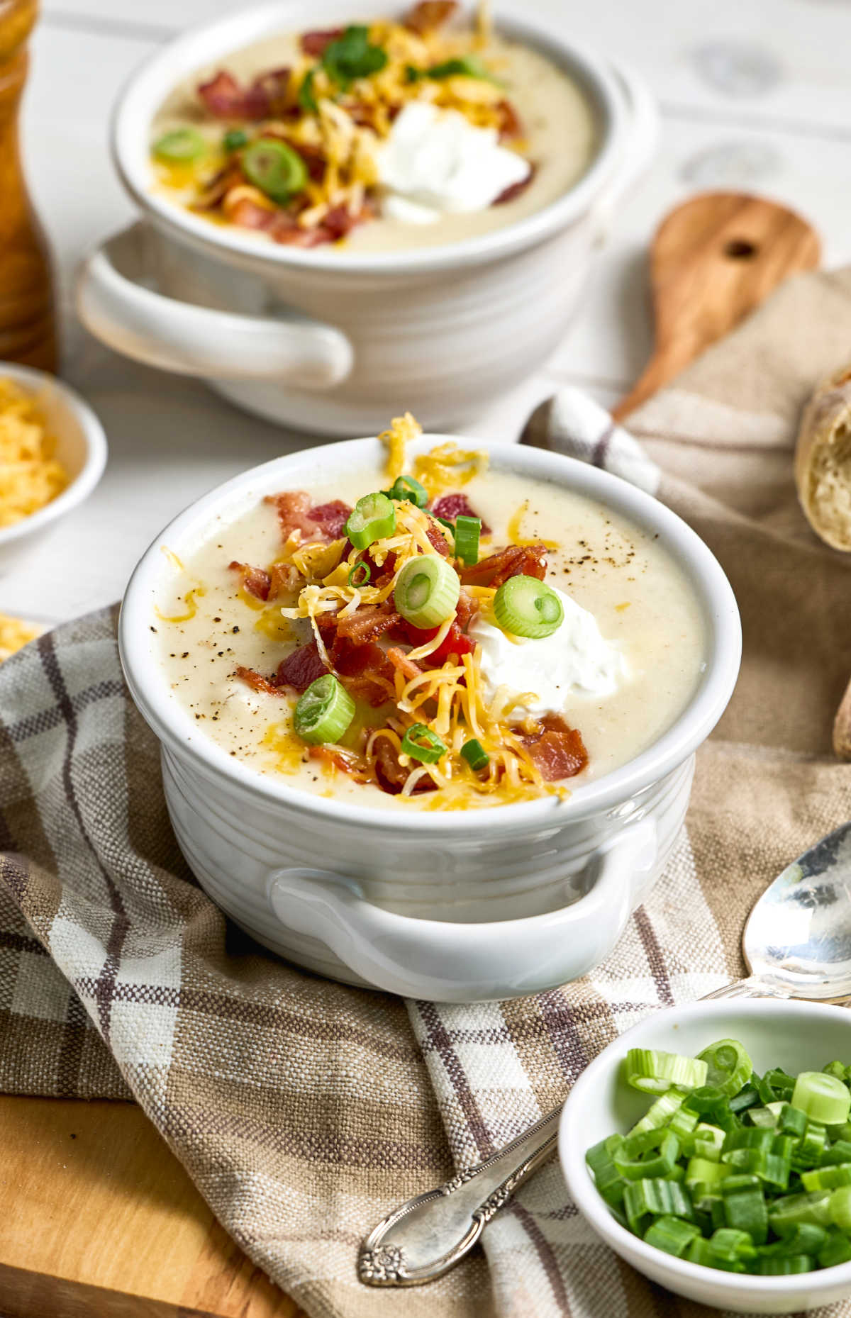 Soup crocks with potato soup on cutting board.