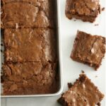 chewy brownies in a square metal baking pan, cut into squares
