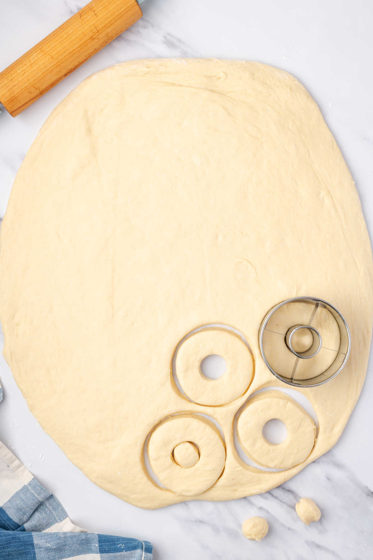 Cutting donuts with cutter out of donut dough.