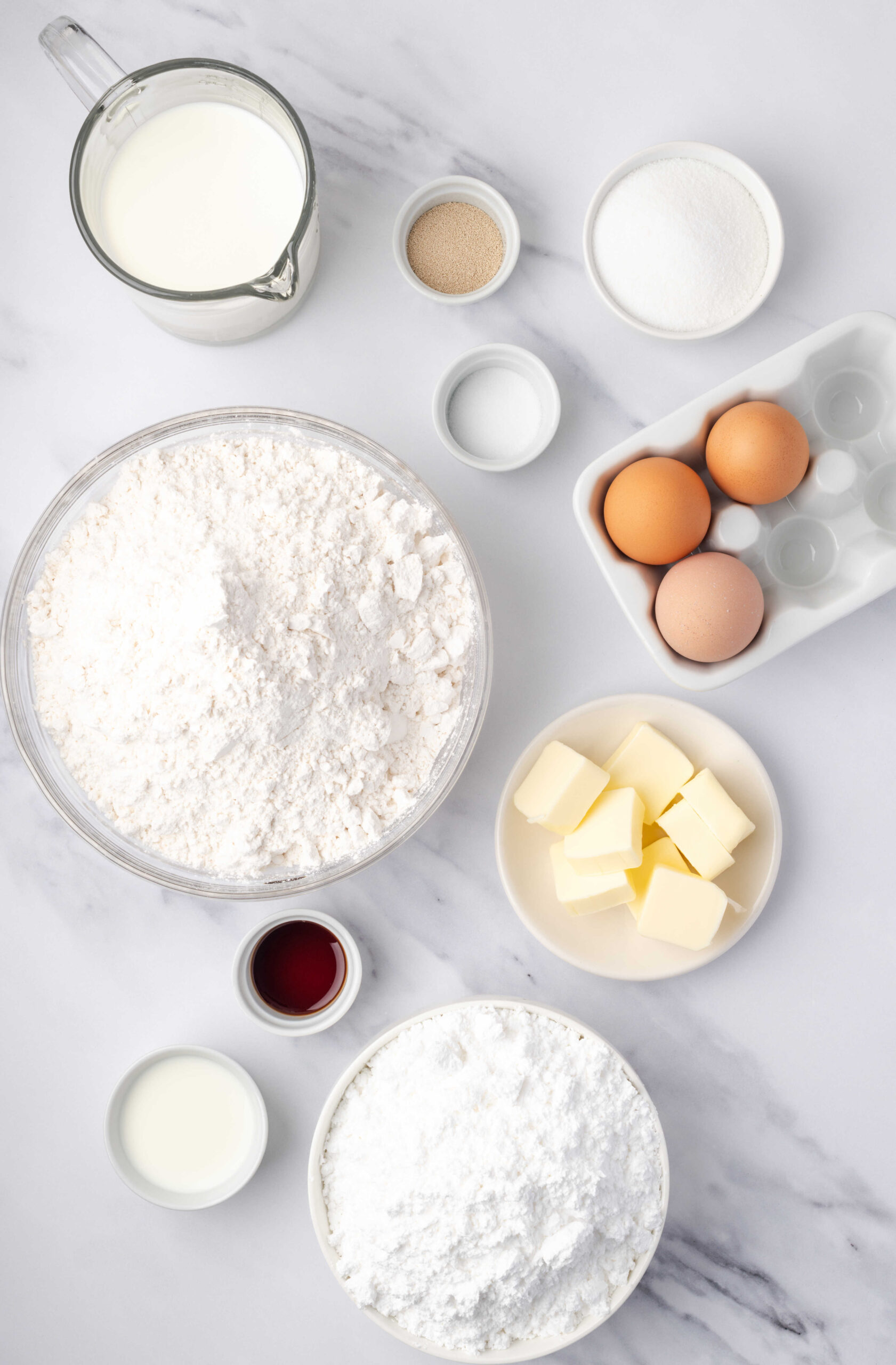 Ingredients in small white bowls for donuts.