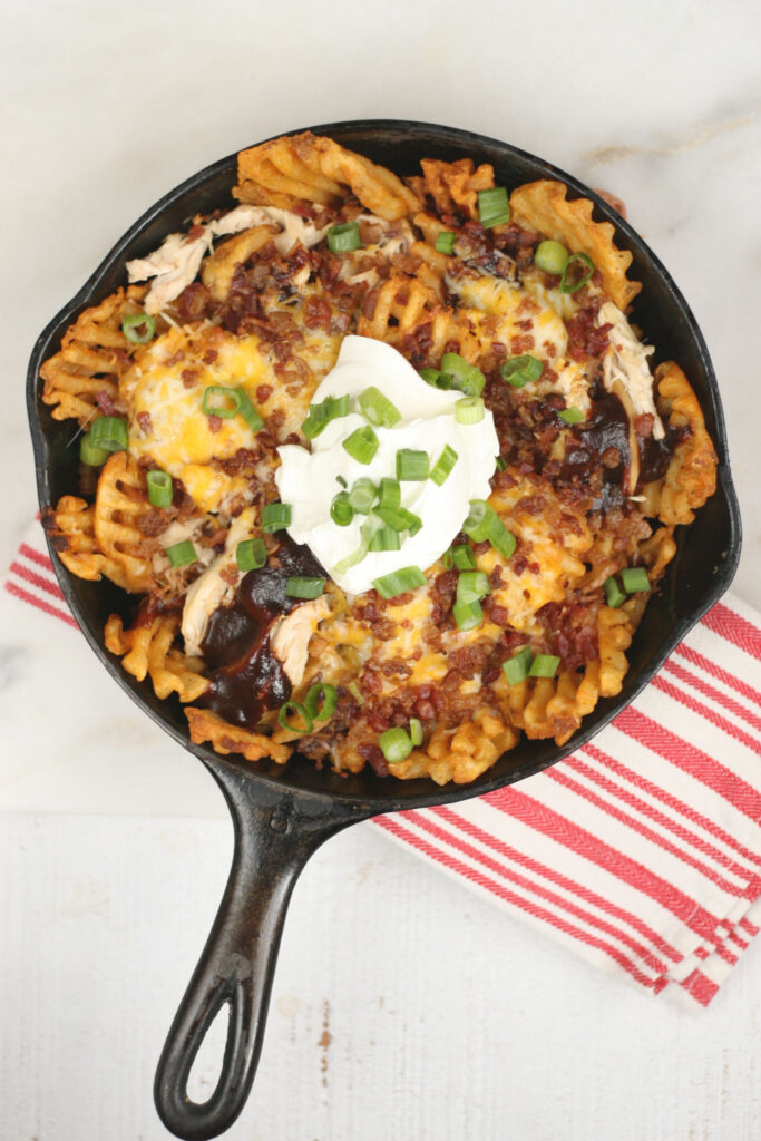 Loaded french fries in a cast iron skillet