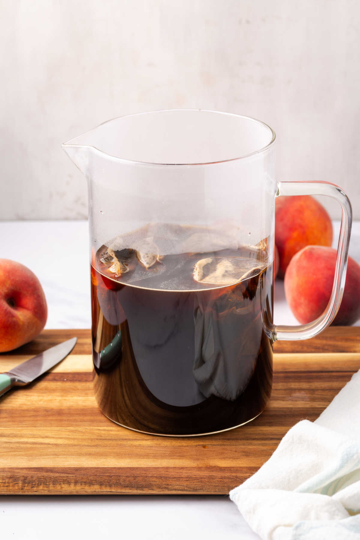 Glass pouring pitcher with tea bags steeping.