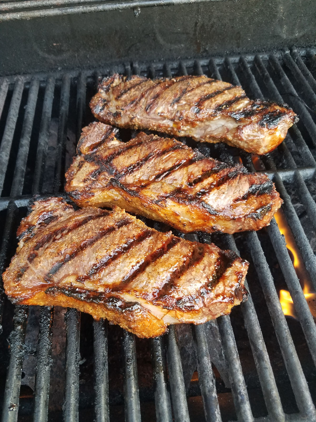 Whiskey marinated steak on a grill.