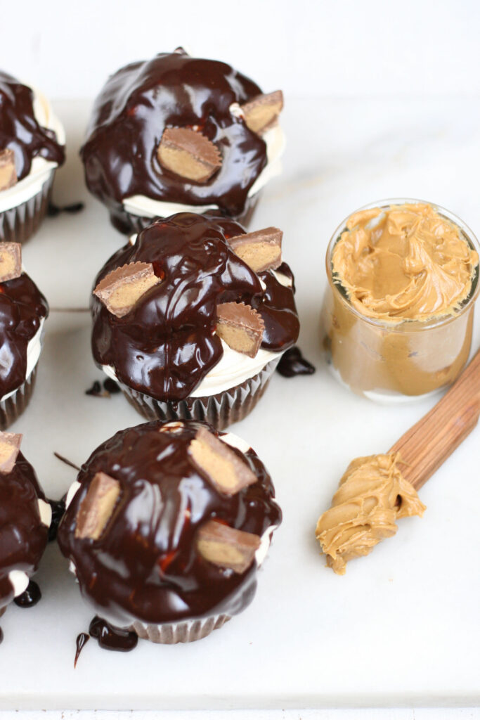 Cupcakes with peanut butter frosting, chocolate ganache, pieces of peanut butter cups on top