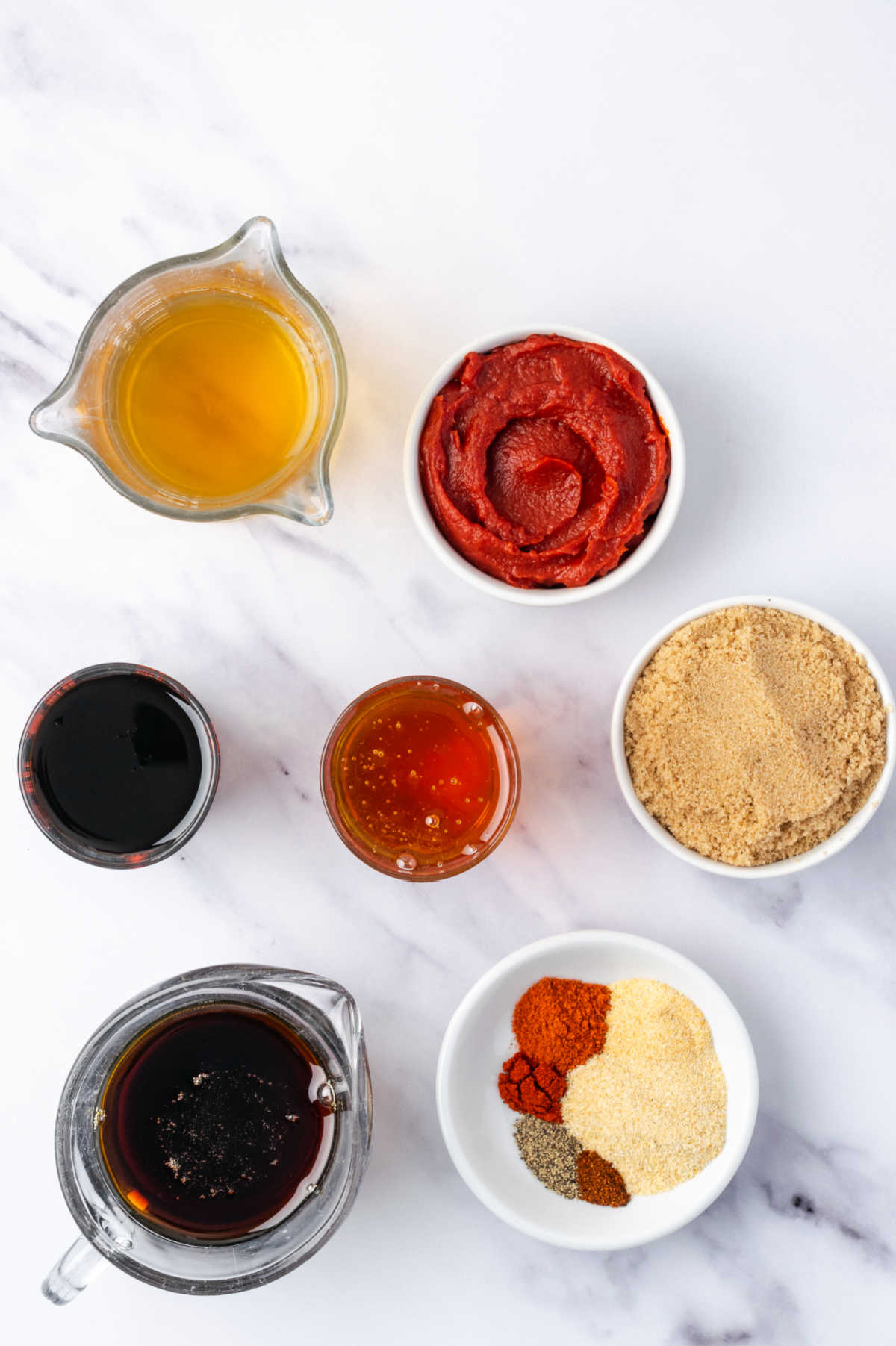 Ingredients in small white bowls for barbecue sauce.