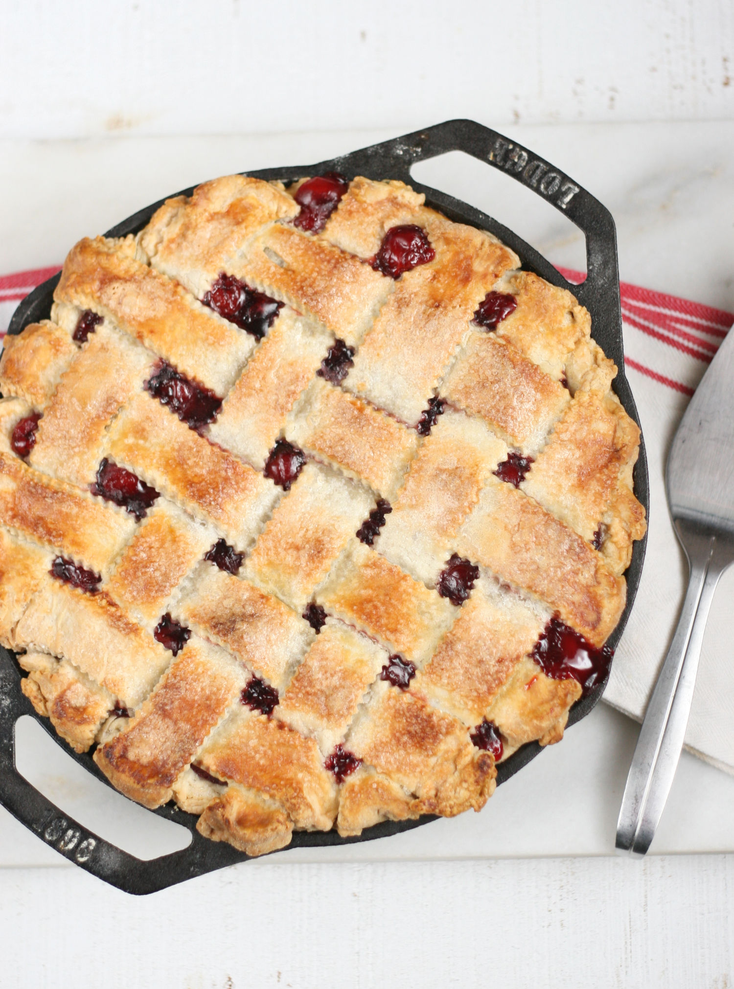 Cherry pie with lattice crust in two handle cast iron pan