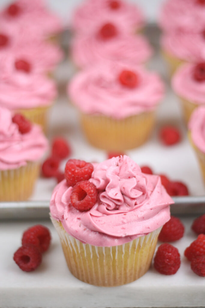 Lemon cupcakes with raspberry frosting and fresh rasperries on top