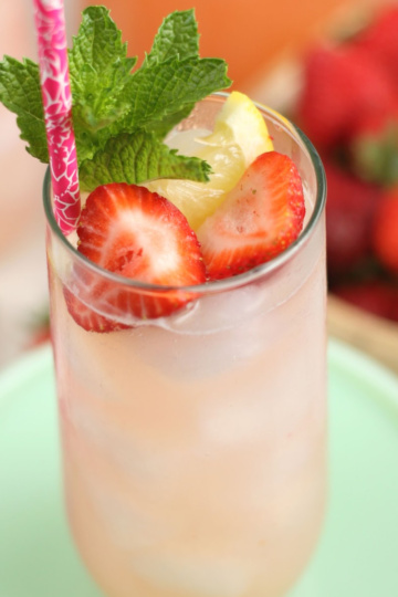 Glass of lemonade with fresh strawberries, lemon and fresh mint.