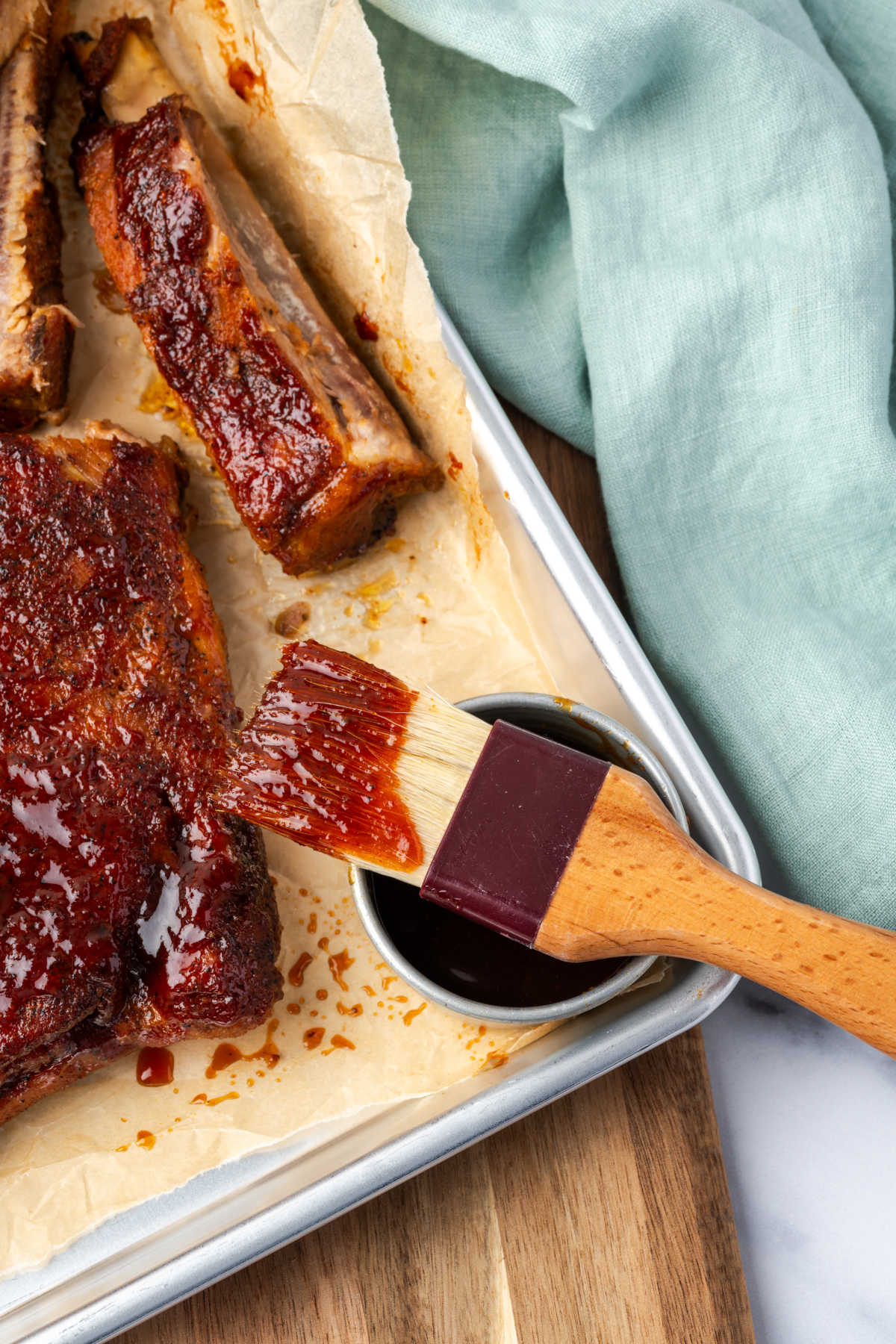 BBQ ribs with barbecue sauce on pastry brush.