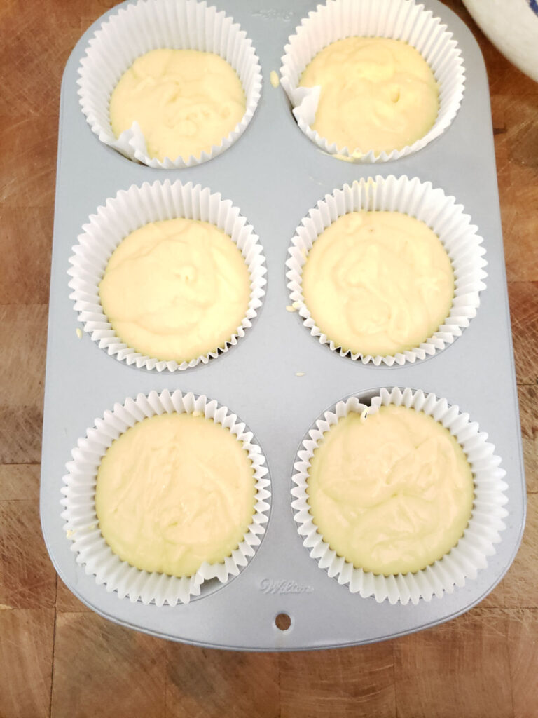 lemon cake batter in jumbo cupcake pan lined with paper liners