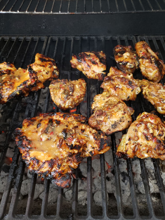 chicken pieces on charcoal grill.