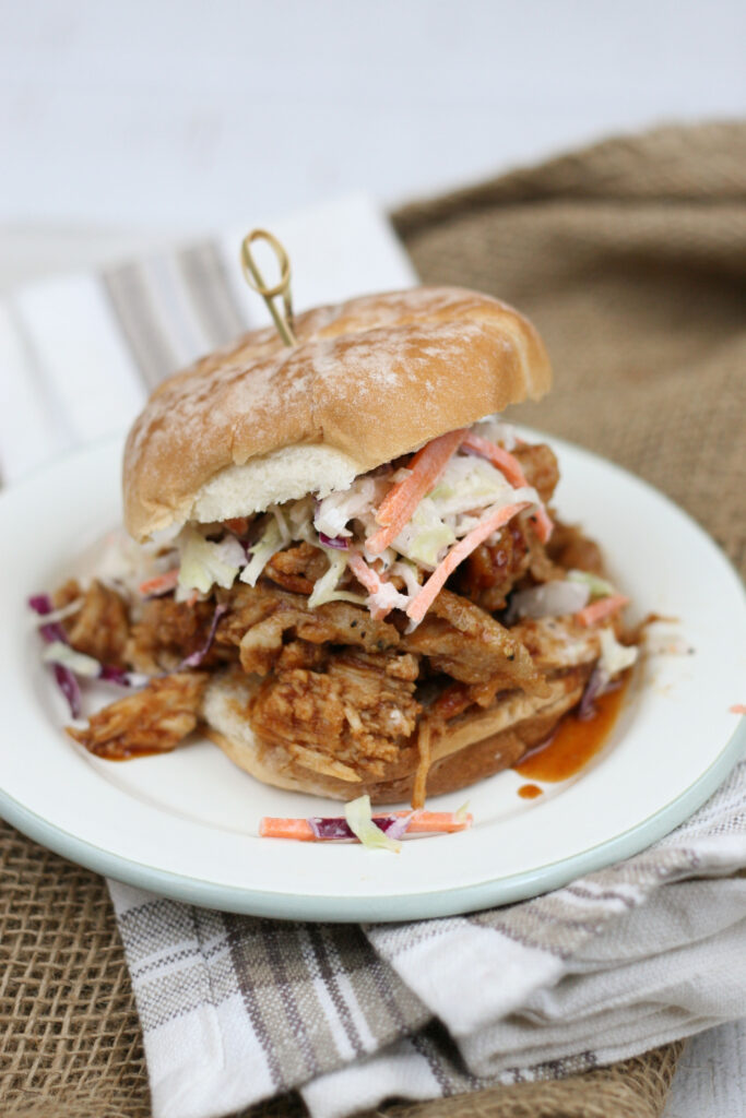 pulled pork sandwiches with homemade slaw on a white plate