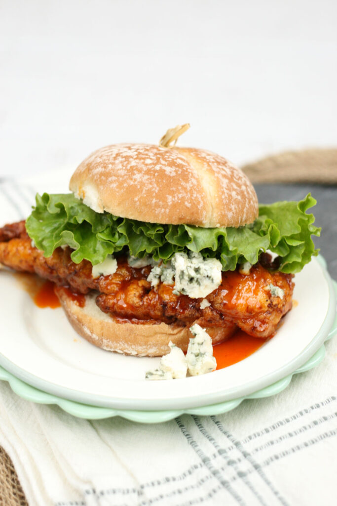 buffallo chicken sandwich on plate with blue cheese and leaf lettuce
