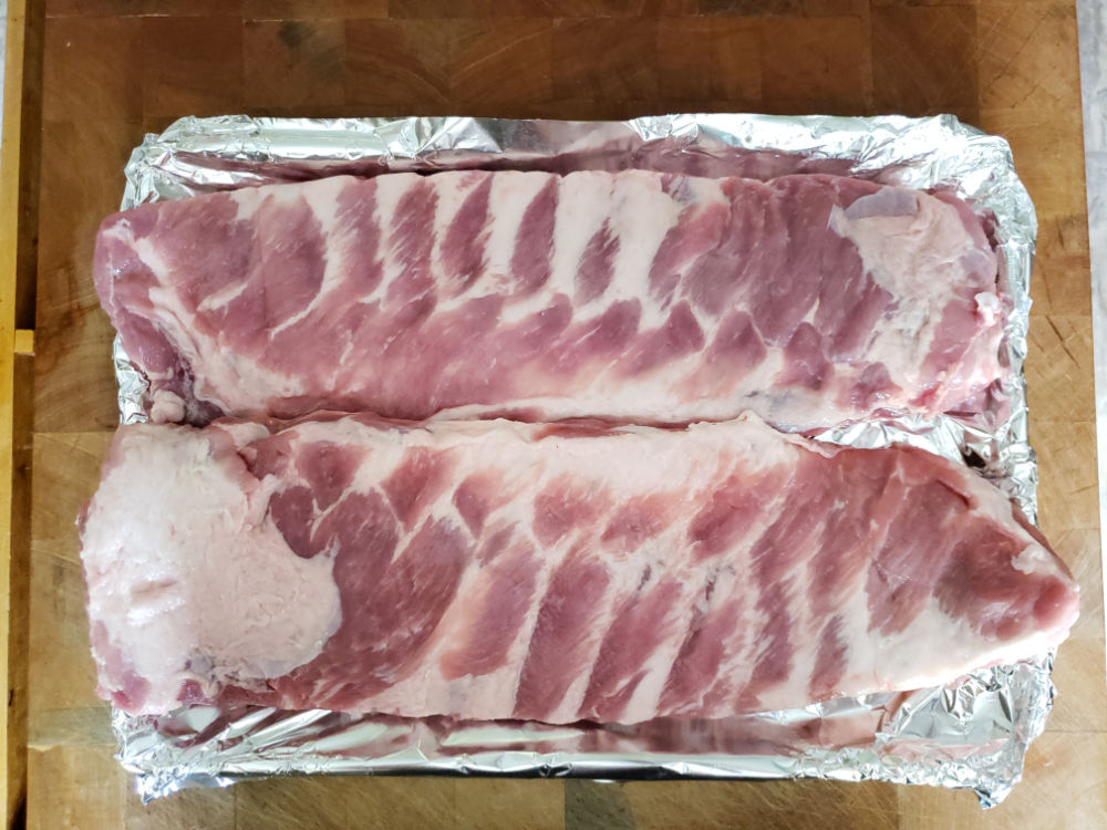 Spare ribs on a half sheet pan lined with aluminum foil