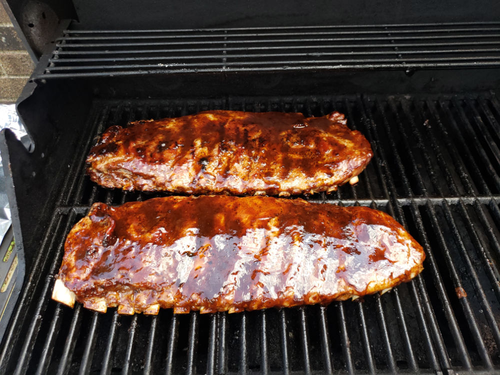 pork ribs on the grill with bbq sauce